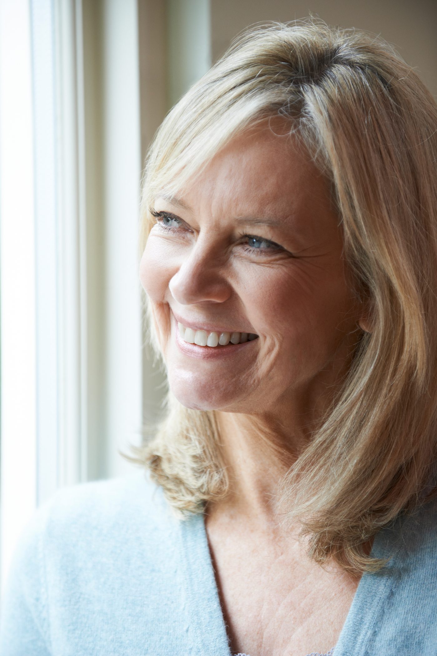 A woman in her fifties looking out of a window