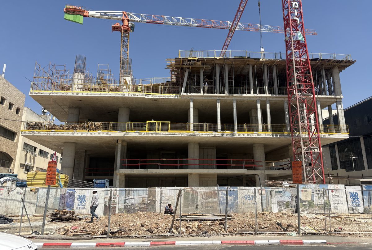 Legacy & A Building In Jerusalem — a multi-storey building under construction in Jerusalem with cranes above the site