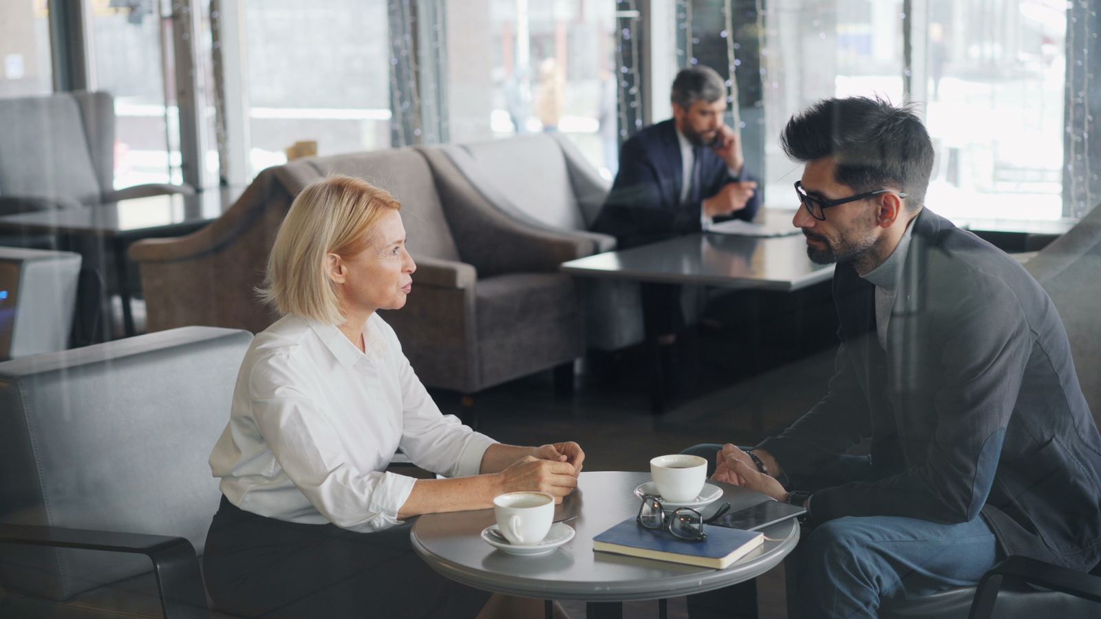 Advisor and client in conversation over coffee